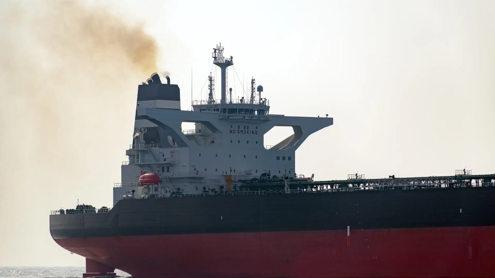 Wheelhouse tanker with an exhaust pipe, open sea.